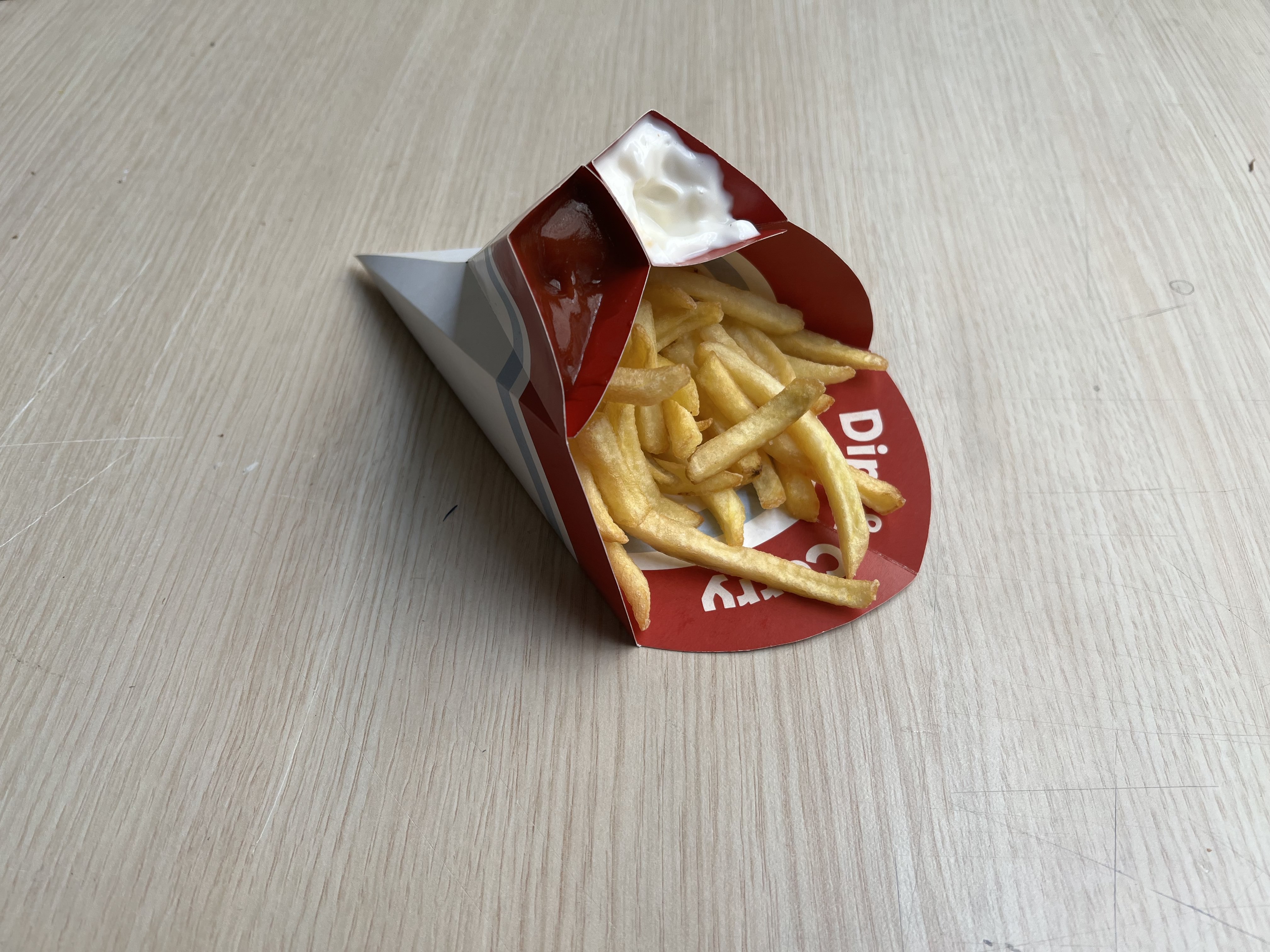 Dip & Carry package placed on a table with fries and two sauces